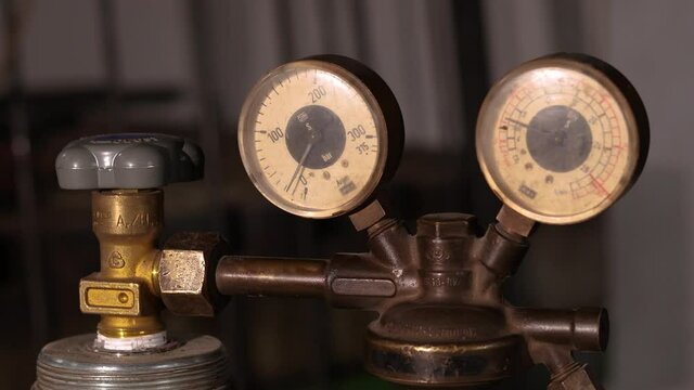 Welding equipment. Acetylene, argon or oxygen gas cylinder tank with gauge regulators manometers. Close up view.