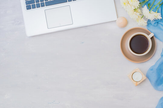 Flat lay home office desktop with laptop, cup of coffee and white flowers on a light background - Powered by Adobe