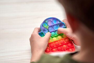 Kids hands push sensory pop it. Colorfull antistress toys, simple dimple, pop tube. Rainbow silicone sensory fidget New popular trendy silicone toy.