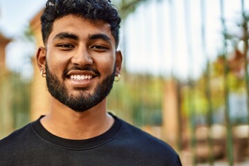 Young arab man smiling confident at street