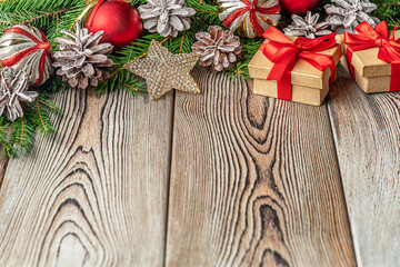 festive christmas and new year background with copy space, fir branches, сhristmas decorations, pine cones and gifts on a vintage wooden table