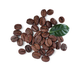 Pile of roasted coffee beans with fresh leaf on white background, top view