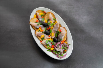 dish of fried potatoes with fish, herring and onions