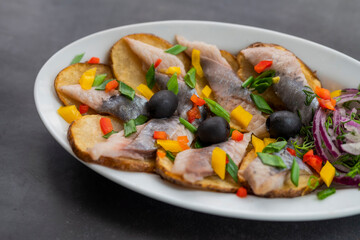 dish of fried potatoes with fish, herring and onions
