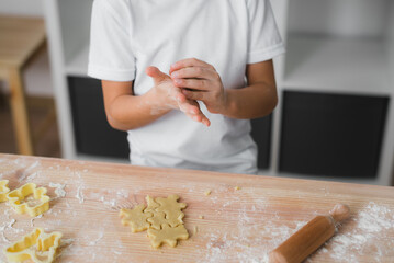 Child's hands knead raw dough for baking