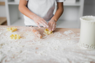 ?hild cuts figured cookies from dough using a culinary mold