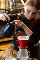 Barista pouring boiling water of manual drip brewer and make cof