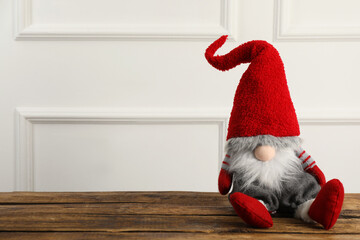 Obraz premium Cute Christmas gnome on wooden table. Space for text