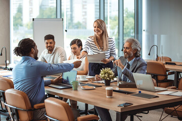 Multi-ethnic group of entrepreneurs discussing business. Finding solutions together. Multi-ethnic professionals are discussing while sitting at desk in office. Team of young architects working