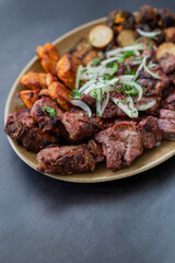 cuts of meat barbecue kebabs grilled pork and beef and chicken on a plate with onions in a restaurant