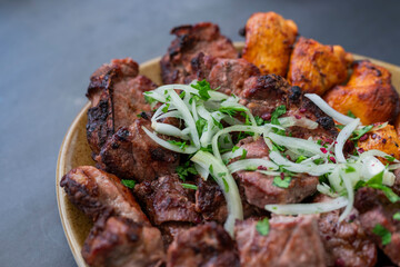 cuts of meat barbecue kebabs grilled pork and beef and chicken on a plate with onions in a restaurant