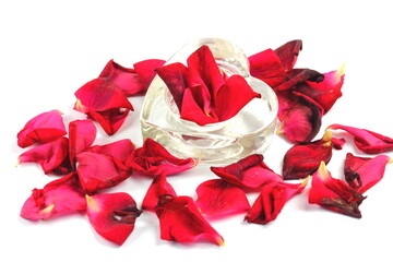 Red rose petals in romantic heart shaped glass dish