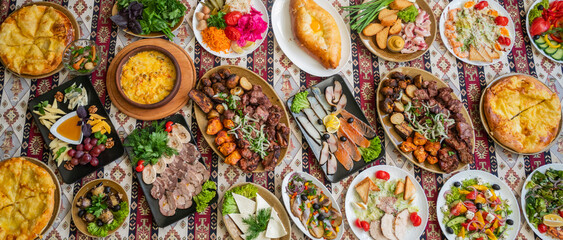 panorama Georgian and Azerbaijani national cuisine dishes suluguni baked khachapuri, mushrooms and vegetables and herbs with a plate of assorted cheeses and salads