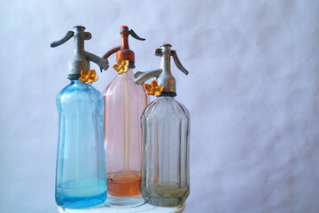 Background with old objects - three bottles of soda water.  Siphon bottles about 100 years old.