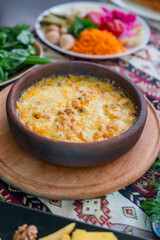 baked suluguni cheese with tomatoes of national Georgian cuisine in earthenware on ketsi