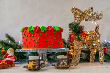 Christmas cake decorated with Christmas trees. Deer with a flashing Christmas garland. Decoration for the holiday. Beautifully served table for the celebration. Copy space.