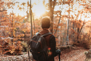 Young man with backpack in the woods. Autumn colors