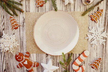 Christmas table setting. Vintage neutral plate mockup among handmade gingerbreads, cookies,...