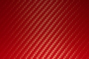 Photo of the texture of red carbon fiber. Sporty red background with carbon pattern of vinyl film. Racing background for text.