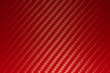 Photo of the texture of red carbon fiber. Sporty red background with carbon pattern of vinyl film. Racing background for text.