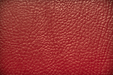 Photo of the texture of genuine leather in red. Leather material for the manufacture of products.