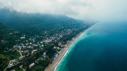 Naklejka premium View from a height of the beach, mountains and sea in cloudy weather. Gagra, Abkhazia