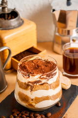 Tiramisu espresso coffee ladyfinger Italian traditional food sweet dessert homemade bakery in glass with beans short grinder