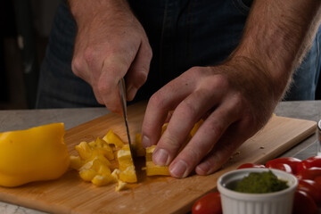 A man Cuts Vegetables on a Wooden Cutting Board. 