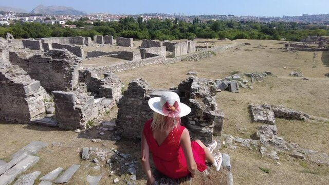 Elegant lady in Salona ruins of Episcopal Center. Ancient Roman city and capital of the Roman province of Dalmatia in Croatia. Old Roman archeological site and the birthplace of Emperor Diocletian.