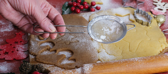 Dough for making New Year's and Christmas cookies.Female hands on the background of a wooden board with cookie dough.