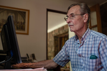 Elderly man using laptop computer. Older man with technology.