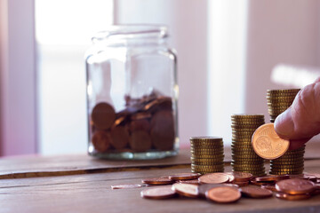 Placing coins saved for counting in the home. Concept of household savings. Copying space.