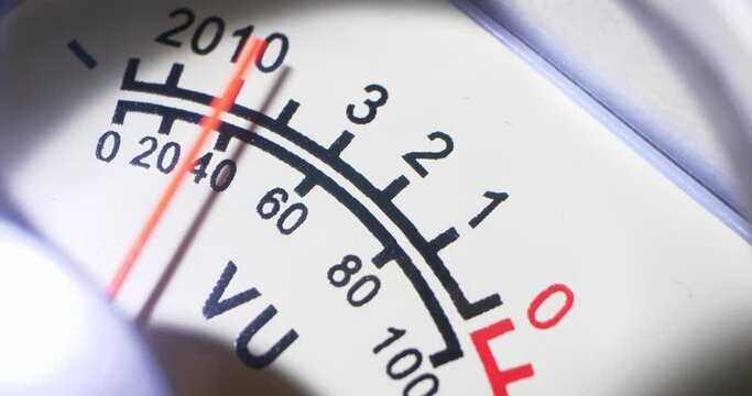 detailed extreme close-up, moving arrow of analog VU meter scale.