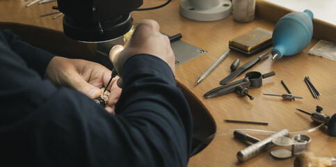 Jeweler's workplace. Tools and equipments for jewelry work on an antique wooden desktop. Jeweller,...