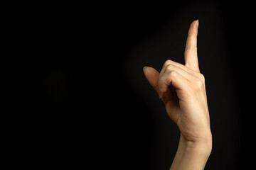 Hand point up. Education concept. Woman hand gesture, pointing sign, gesture look at this, pay attention. Black background photo