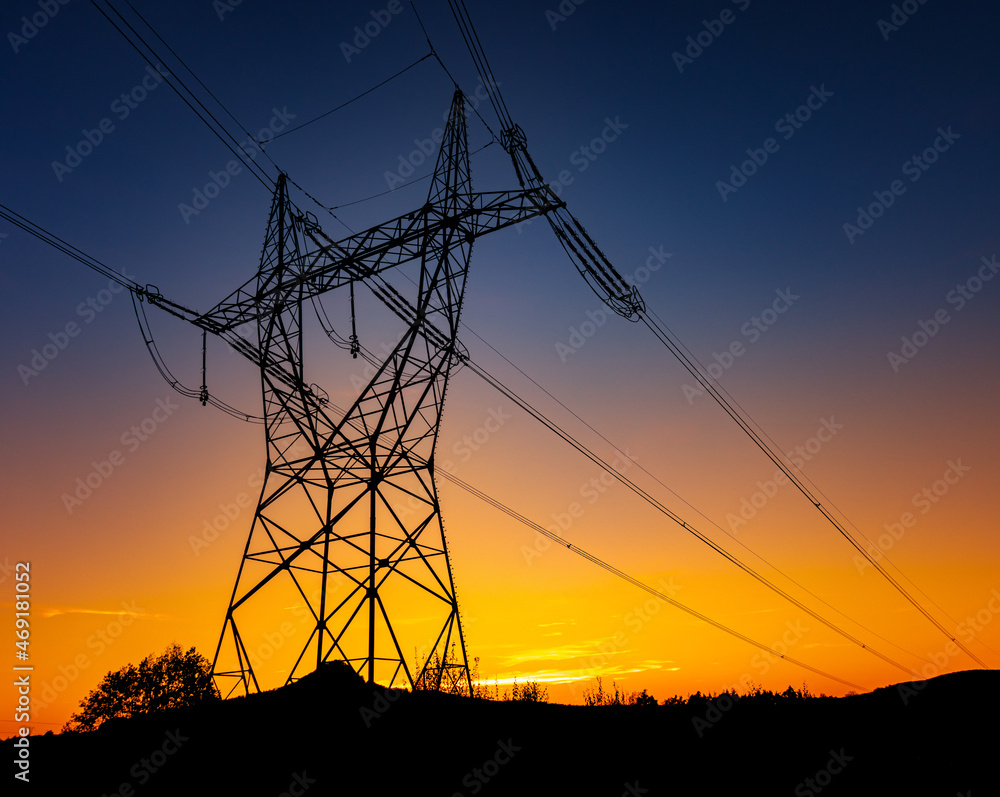 Wall mural silhouette of a high voltage tower with the sunset on a background