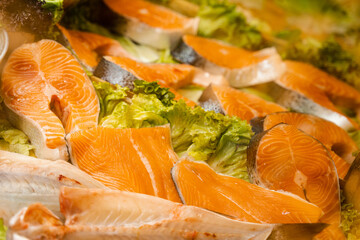 Salmon steaks with lettuce close-up. Fresh raw red fish.