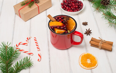 Christmas white wooden background with mulled wine in red mug, Christmas gift box, anise and spruce branches.  Side view selective focus.