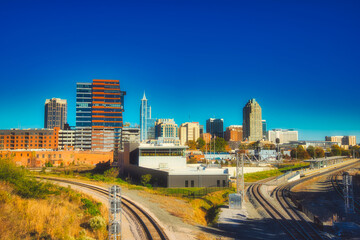 Fototapeta na wymiar A nice city skyline of Raleigh North Carolina with train tracks in artistic colors.