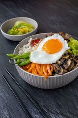 Traditional Korean dish - bibimbap , rice bowl with vegetables , egg and ground beef.