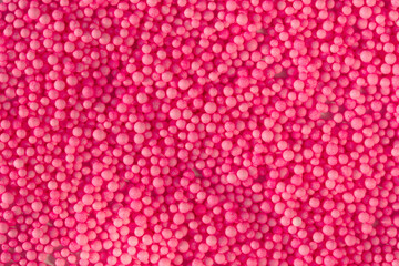 Many pink little balls for children playground. Cosmetics powder. Candy sprinkles. Top view. Trendy absract background or backplate for your design