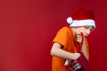 a boy with a Christmas bag rummages in search of gifts