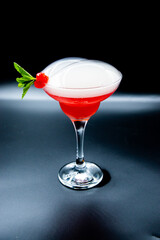red cocktail with smoke on black background