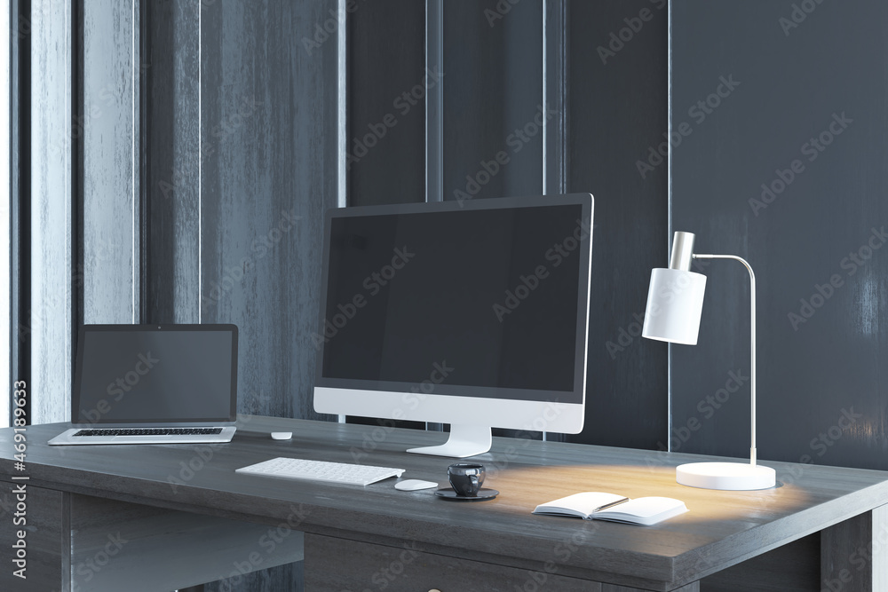 Poster Antique wooden desk with empty computer and laptop screens, table lamp, coffee cup and other items. Workpace and office workspace concept. Mock up, 3D Rendering.