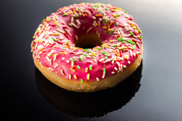 donut with pink cream, on a black background, on the mirror, side view, пончик с розовым кремом, на черном фоне, на зеркале, вид сбоку