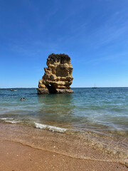 Praia Dona Ana beach with turquoise sea water and cliffs, flying seagulls over the beach, Portugal. Beautiful Dona Ana Beach (Praia Dona Ana) in Lagos, Algarve, Portugal..