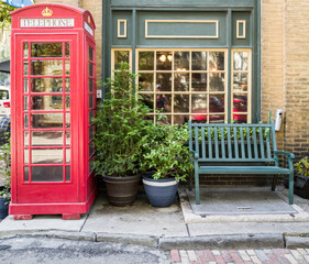 Fototapeta na wymiar Vintage red telephone booth and bench