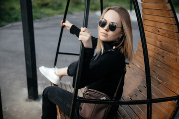 Young woman is relaxing in a hammock chair outdoors on a sunny day. Summer holidays