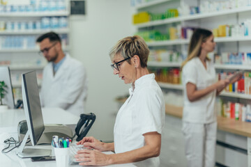 Fototapeta na wymiar Senior female pharmacist working in a pharmacy