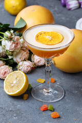 Orange cocktail with a slice of orange on a black concrete background. Summer cocktail concept with decor